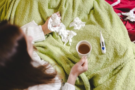 Sick Woman at Home with Tissues, Tea, Thermometer
