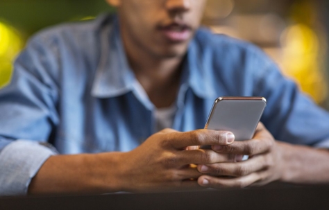 Man sitting at table and holding his cell phone