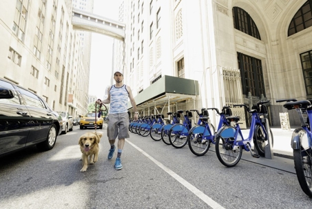 man walking dog on a city street
