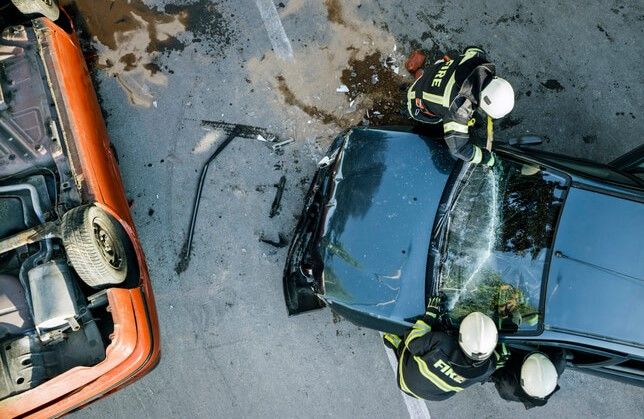 firefighters rescuing person from car accident