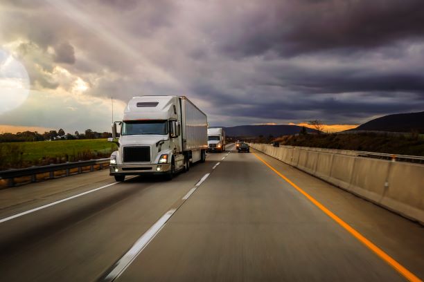 semi truck driving next to a passenger truck on the highway